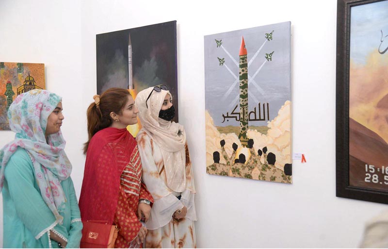 Women viewing painting during exhibition on the occasion of Youm e Takbir at Al-Hamra hall Lahore.